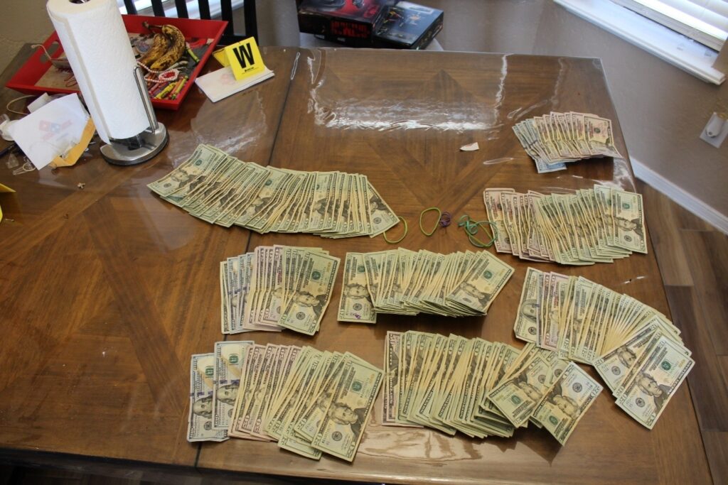 Stacks of paper currency spread across a wooden table